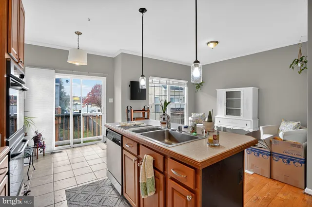 a kitchen with a sink a counter top space and living room view