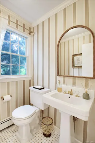 a bathroom with a sink a toilet and a mirror