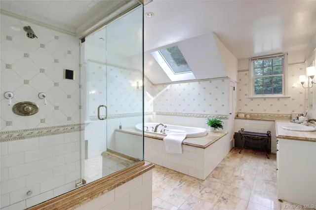 a spacious bathroom with a tub sink and mirror