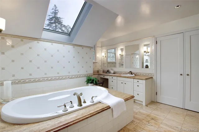 a bathroom with a tub sink and mirror