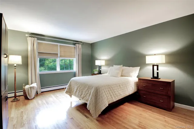 a bedroom with a large bed and a wooden floor