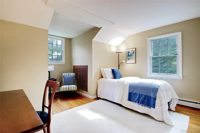 a bedroom with a bed chair and a window