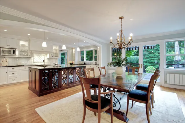 a dining room with furniture a chandelier and wooden floor