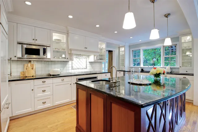a kitchen with granite countertop a sink a counter top space appliances and cabinets