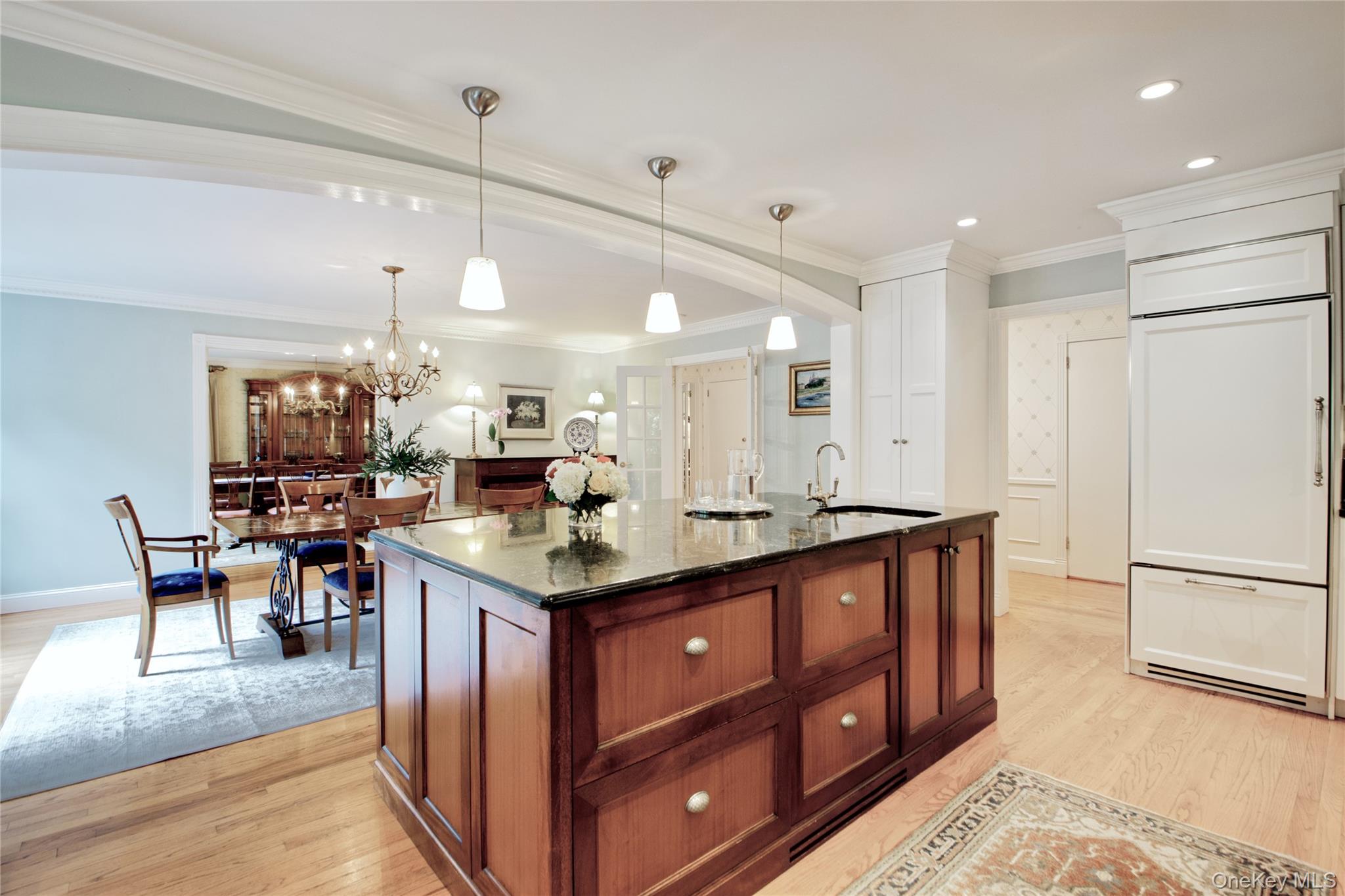 4 Kimson Court Manhasset, NY 11030 - Photo 10 of 30 a kitchen with stainless steel appliances granite countertop a stove refrigerator a dining table and chairs with wooden floor