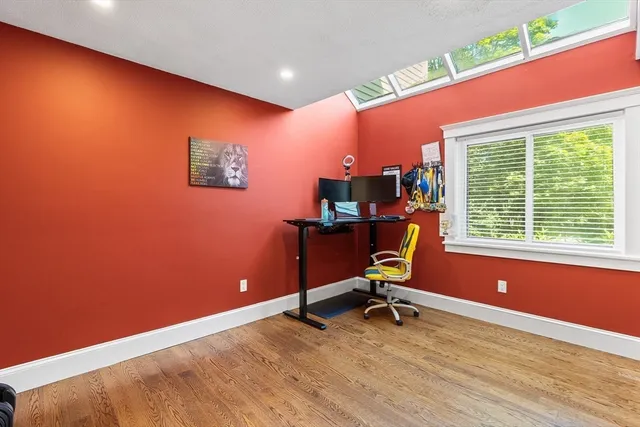 a view of a workspace with furniture and a window