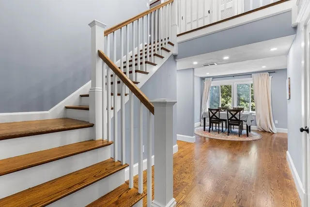 a view of entryway and dining room with wooden floor