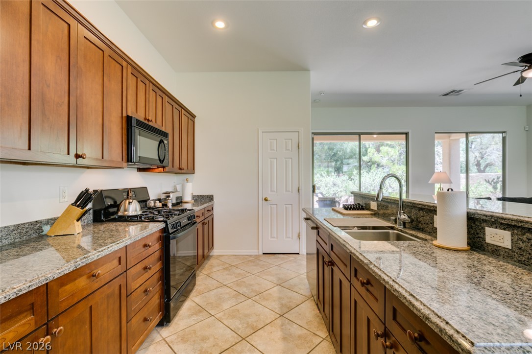 8 Kennesaw Road Henderson, NV 89052 - Photo 24 of 44 A functional kitchen boasts ample counter space, rich wood cabinetry, and seamless flow to outdoor views.