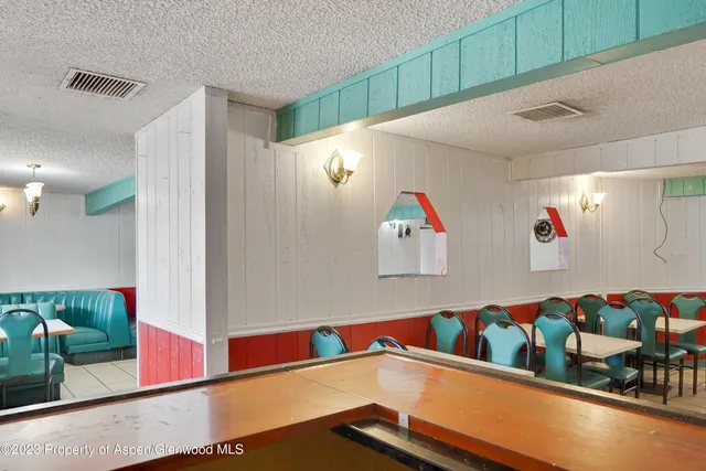 a blue painted wall with a refrigerator