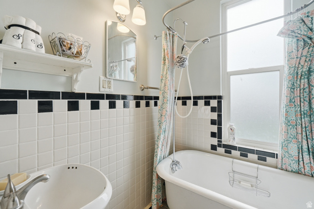 5264 West 5500th Street South Hooper, UT 84315 - Photo 21 of 38 White tiled bathroom featuring a clawfoot tub with an overhead shower, a pedestal sink, and a frosted window