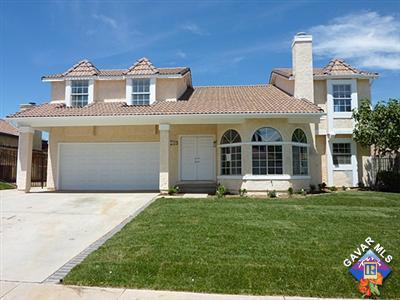 a front view of a house with a garden and yard