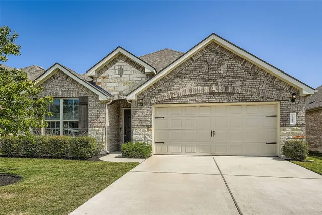 a view of a house with garage and plants