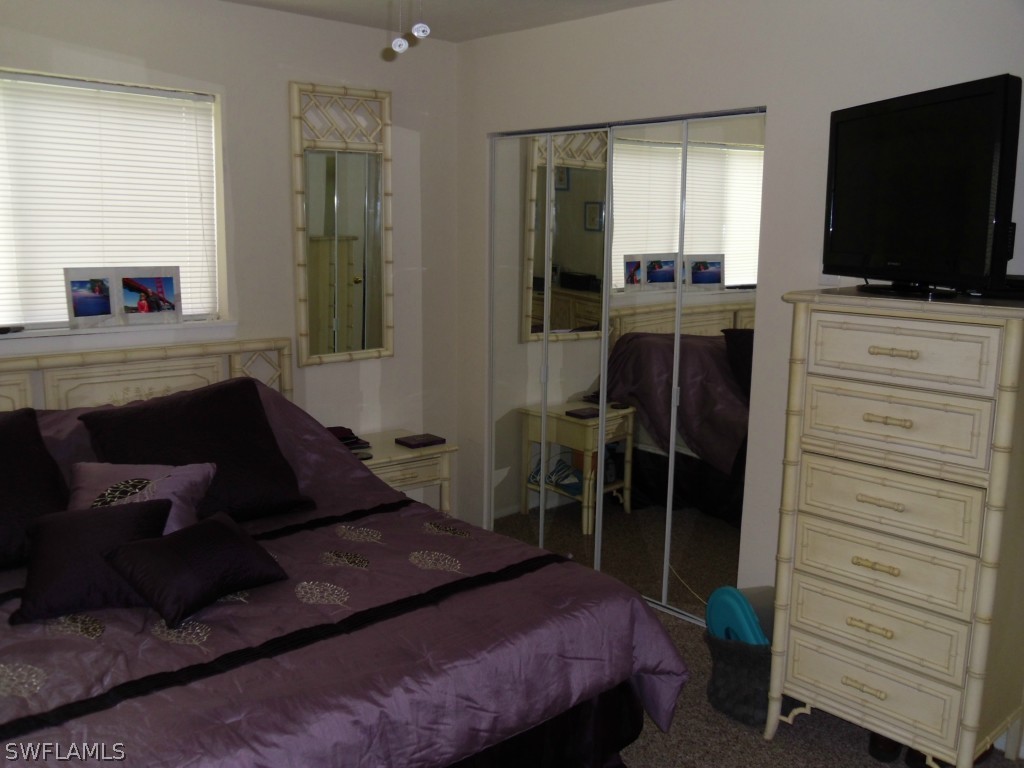 18583 Evergreen Road Fort Myers, FL 33967 - Photo 16 of 17 a bedroom with a bed and a flat tv screen on dresser