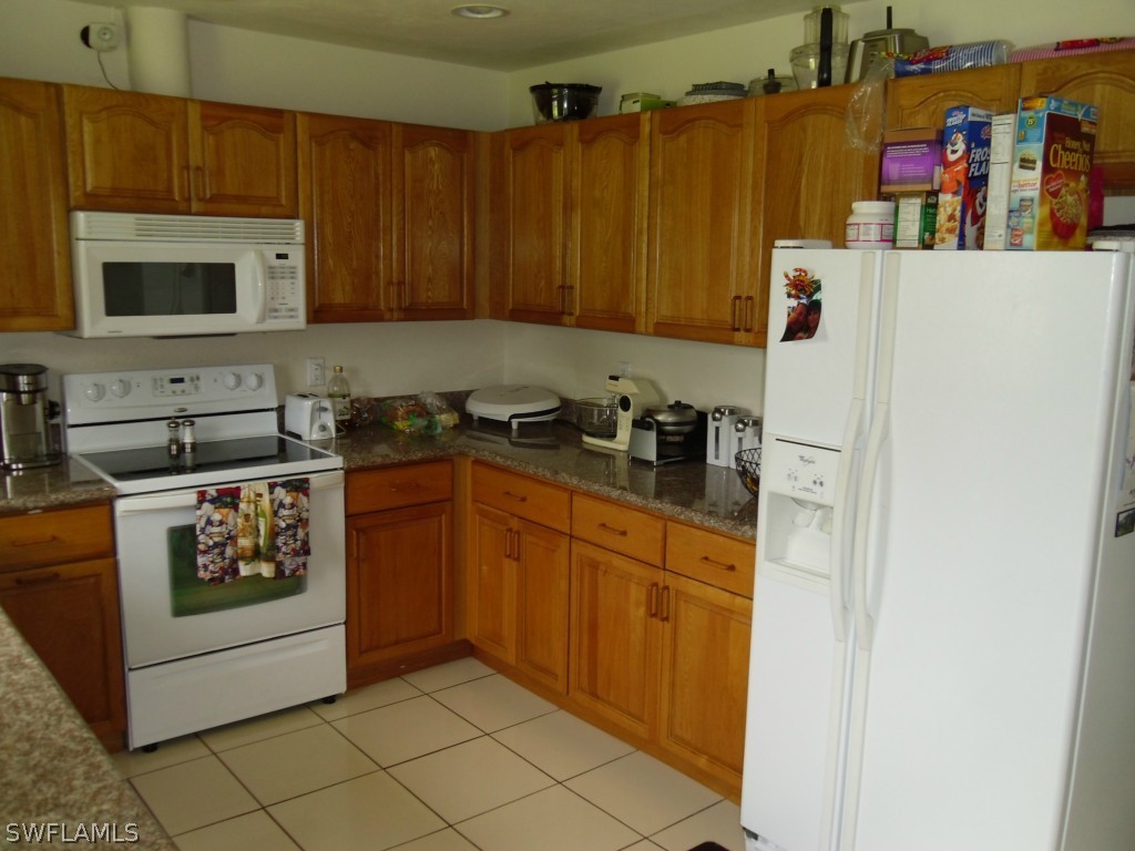 18583 Evergreen Road Fort Myers, FL 33967 - Photo 3 of 17 a kitchen with stainless steel appliances granite countertop a refrigerator a stove a sink and dishwasher