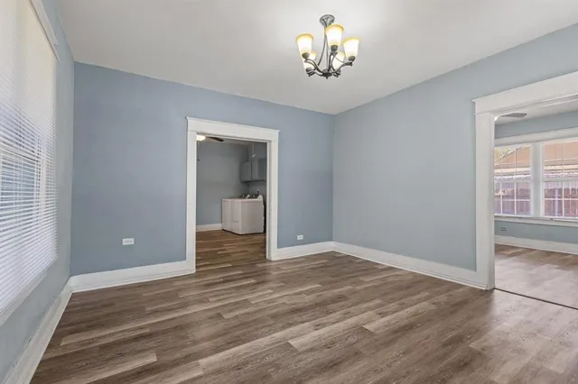 a view of empty room with wooden floor and window