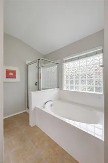 a spacious bathroom with bathtub and shower