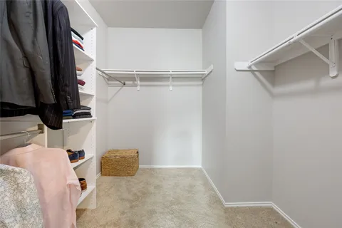 a view of walk in closet with clothes and shoes