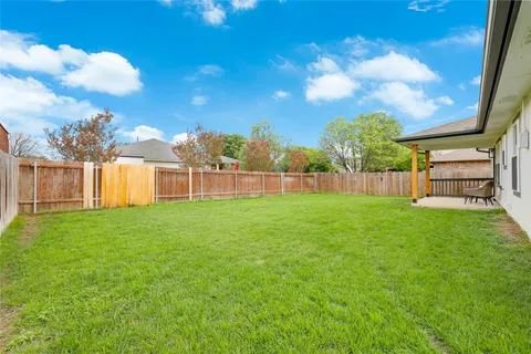a view of yard with grass and a fence