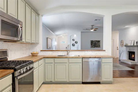 a kitchen with stainless steel appliances granite countertop a stove a sink and a microwave