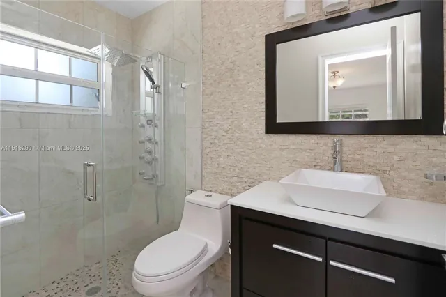 a bathroom with a toilet sink and mirror