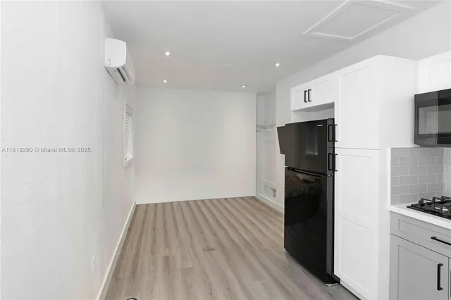 a view of a kitchen with a refrigerator and a stove top oven