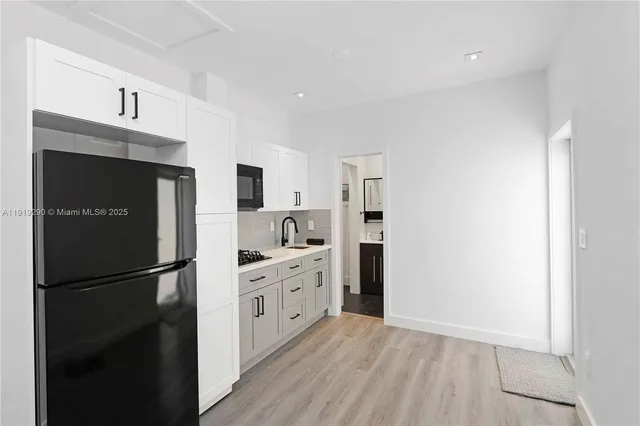 a kitchen with stainless steel appliances a refrigerator sink and cabinets
