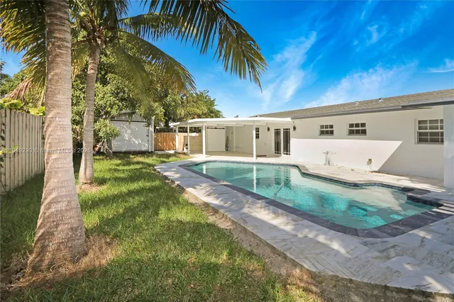 a view of a house with backyard and sitting area