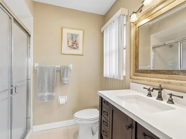 a bathroom with a granite countertop sink toilet and shower