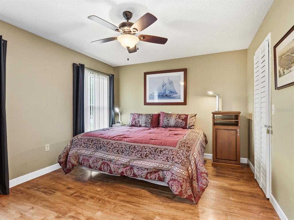 5107 Greencroft Road, Unit 23 Sarasota, FL 34235 - Photo 15 of 35 a bedroom with a large bed and a chandelier