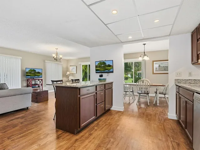 a large living room with stainless steel appliances granite countertop a couch and a wooden floors