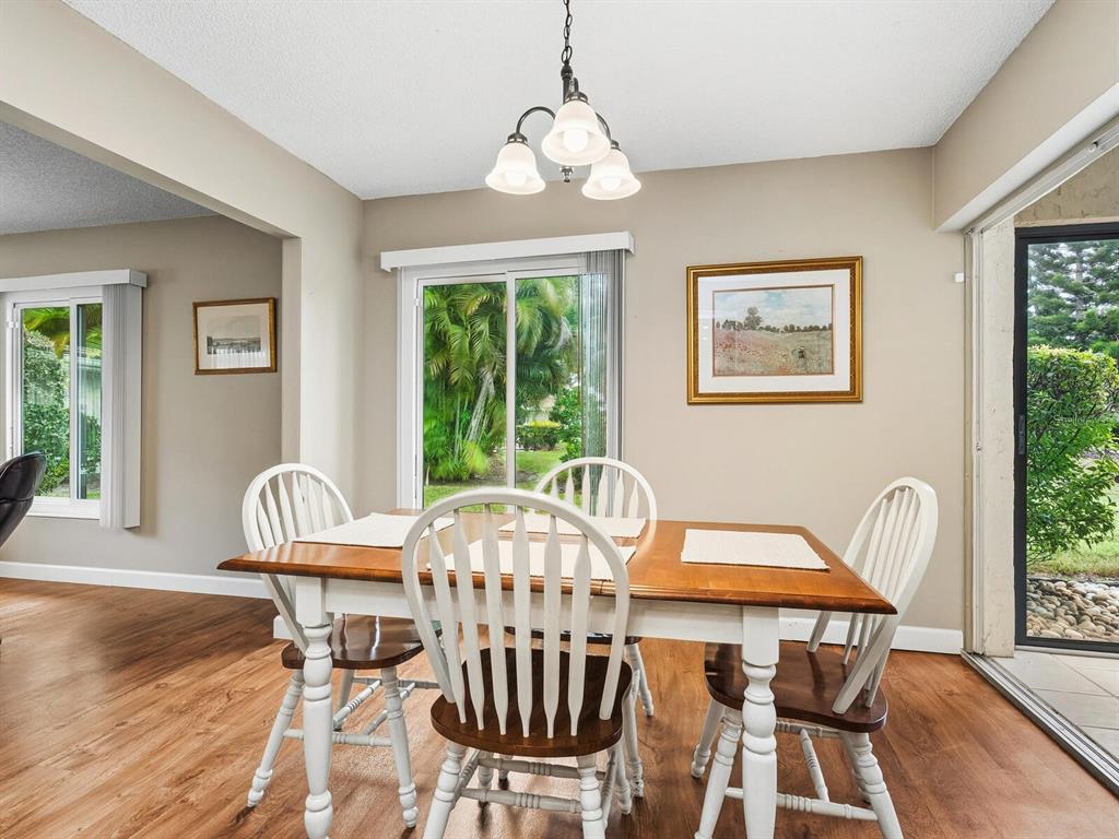 5107 Greencroft Road, Unit 23 Sarasota, FL 34235 - Photo 10 of 35 a view of a dining room with furniture window and wooden floor