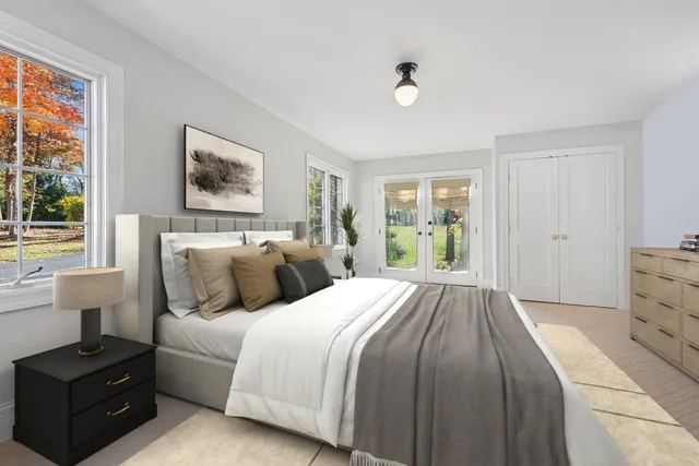 a view of a house with a yard plants and large tree