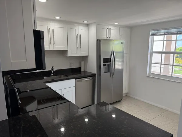 a kitchen with stainless steel appliances a refrigerator sink and microwave