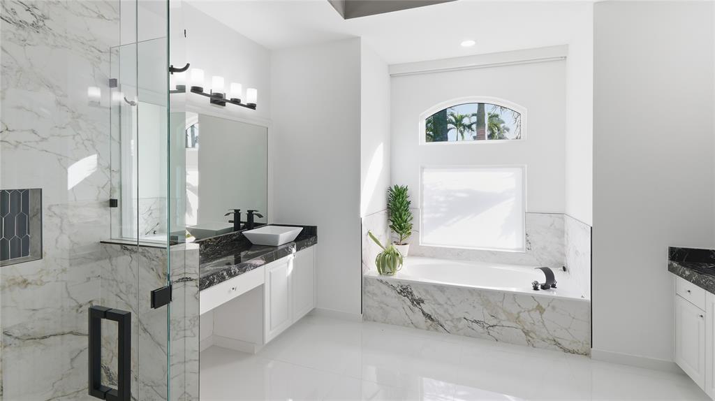 10141 Umberland Place Boca Raton, FL 33428 - Photo 17 of 28 a spacious bathroom with a bathtub sink and mirror