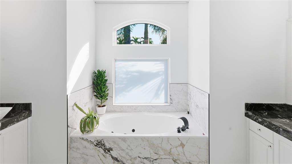 10141 Umberland Place Boca Raton, FL 33428 - Photo 19 of 28 a bathroom with a bathtub and a window