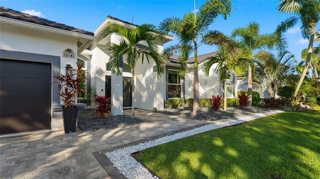 10141 Umberland Place Boca Raton, FL 33428 - Photo 4 of 28 a view of a backyard with plants and palm trees