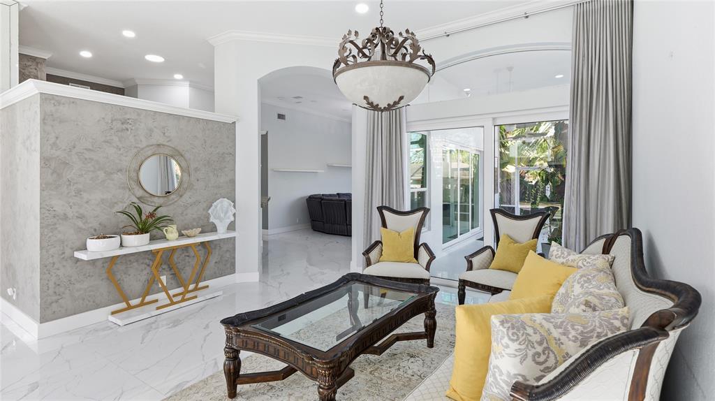 10141 Umberland Place Boca Raton, FL 33428 - Photo 7 of 28 a living room with furniture and a chandelier