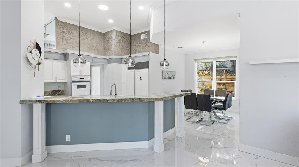 10141 Umberland Place Boca Raton, FL 33428 - Photo 10 of 28 a kitchen with stainless steel appliances kitchen island granite countertop a sink and cabinets