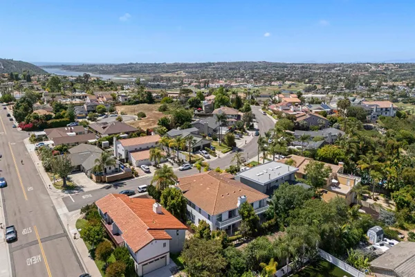 an aerial view of residential houses with outdoor space and trees