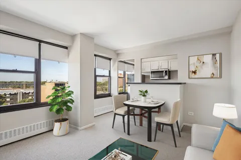 a dining room with furniture and potted plants
