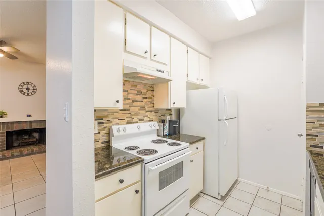 a kitchen with a stove top oven and cabinets