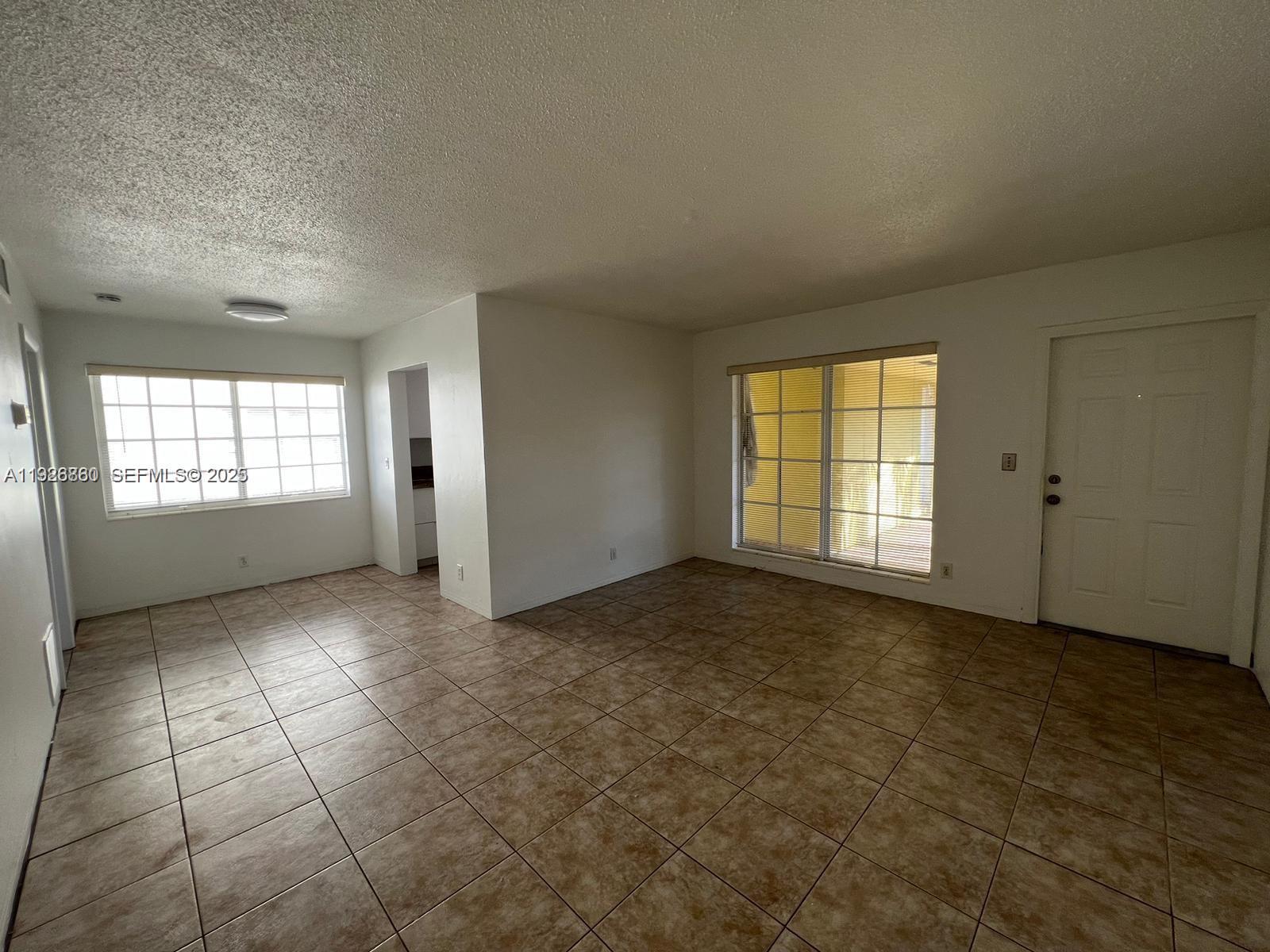 105 Northeast 12th Avenue, Unit 17 Hallandale Beach, FL 33009 - Photo 1 of 11 an empty room with windows
