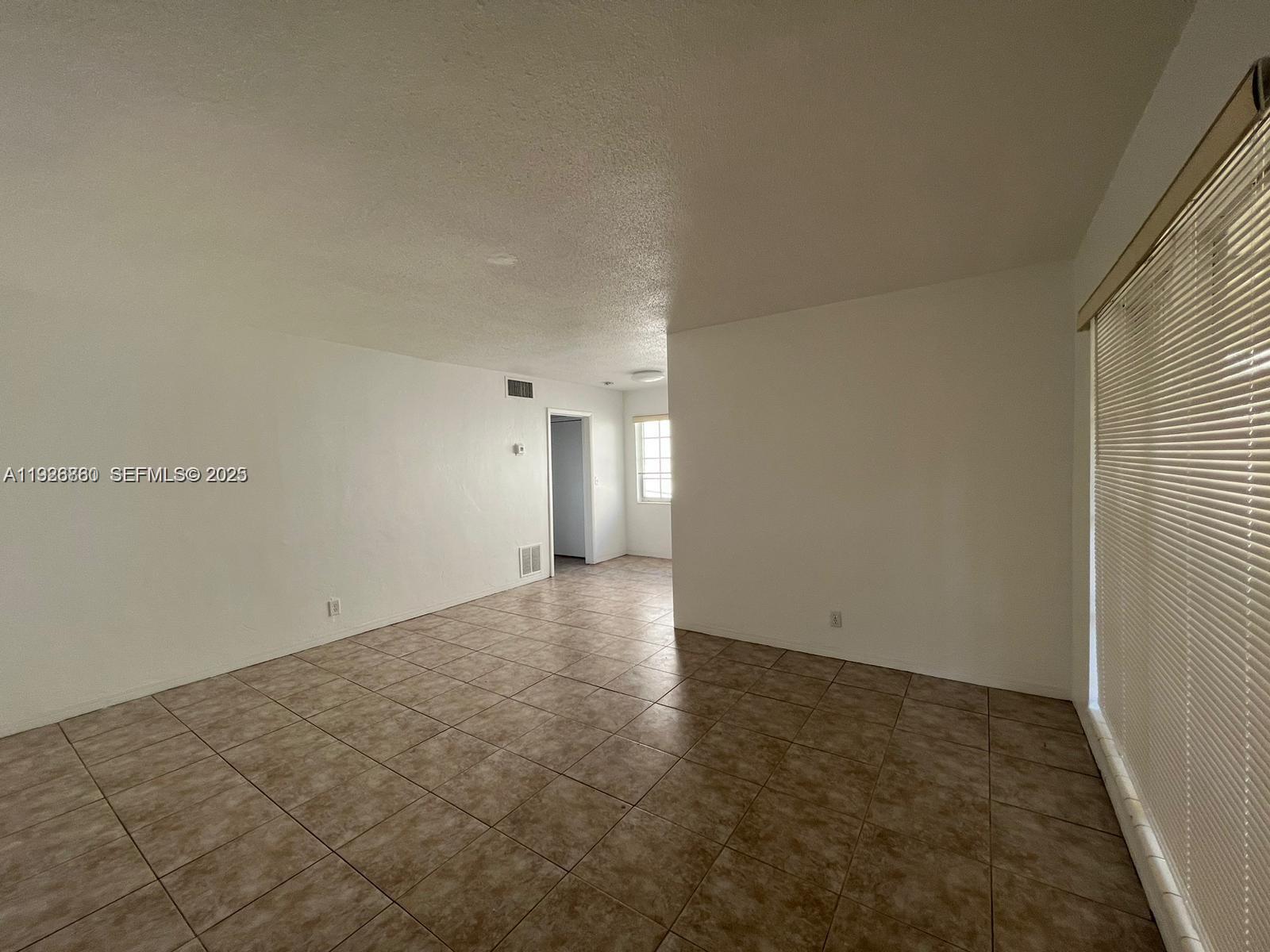 105 Northeast 12th Avenue, Unit 17 Hallandale Beach, FL 33009 - Photo 2 of 11 an empty room with an entryway