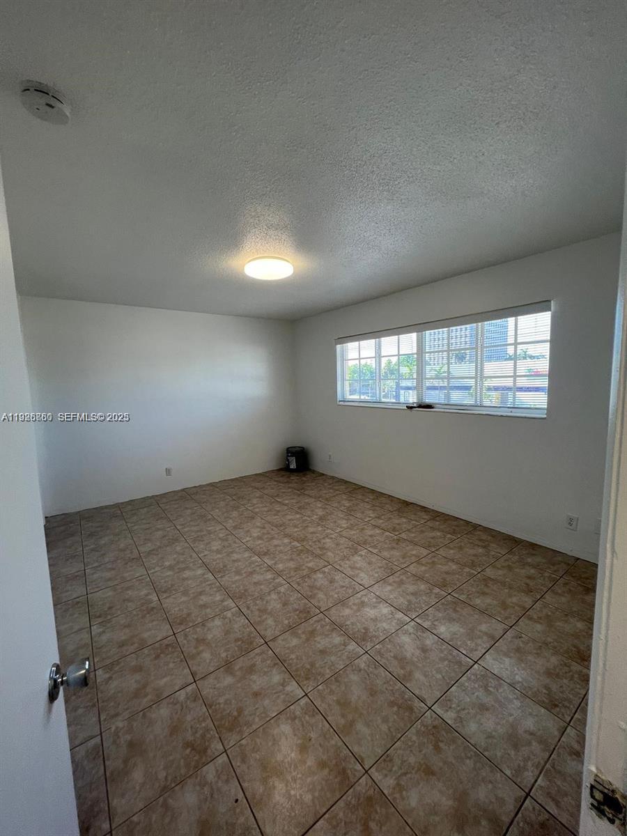105 Northeast 12th Avenue, Unit 17 Hallandale Beach, FL 33009 - Photo 4 of 11 an empty room with windows