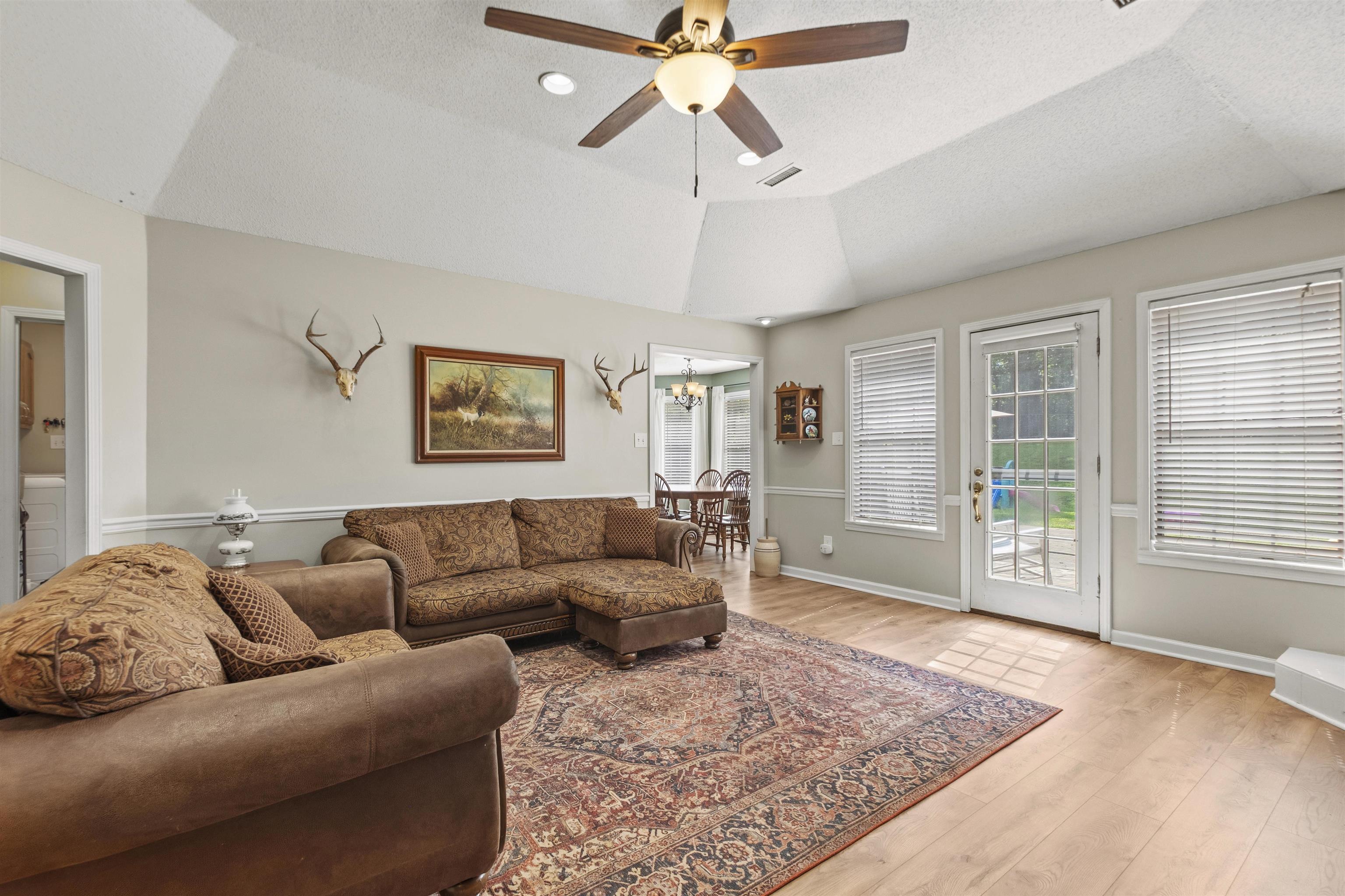 3601 Marshall Road Munford, TN 38058 - Photo 17 of 35 Living area featuring a tray ceiling with a ceiling fan, light wood-finish flooring, and light-colored walls with white trim