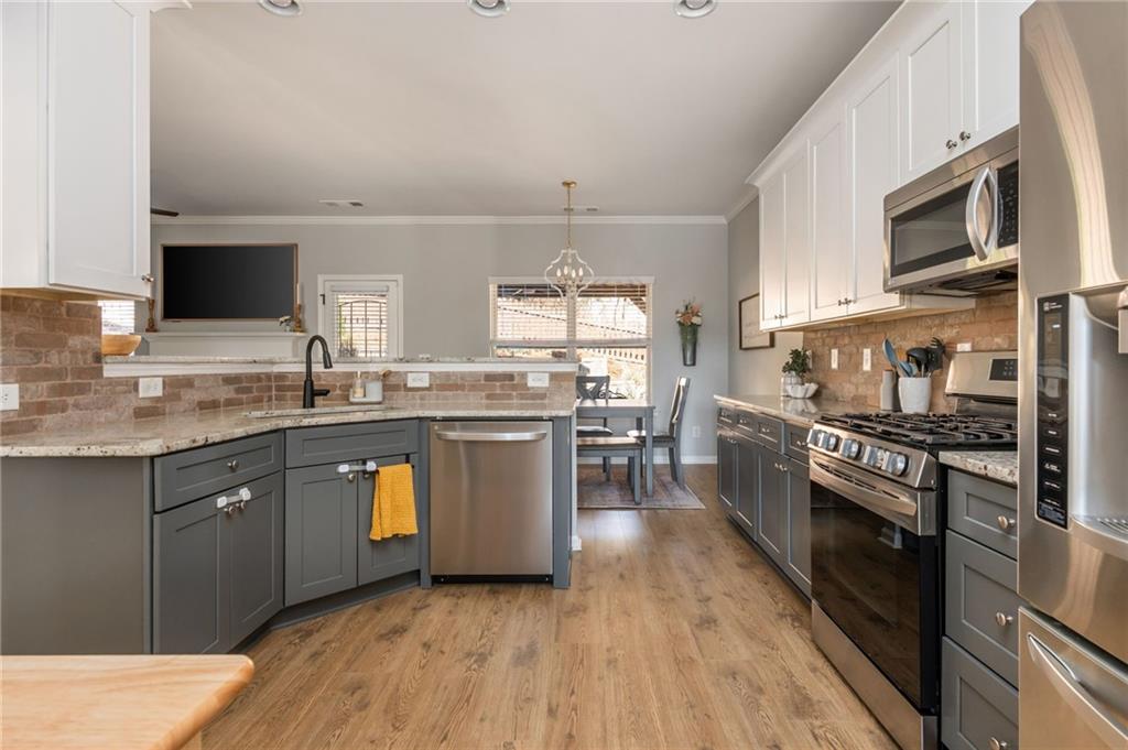 503 Pinnacle Court Canton, GA 30115 - Photo 12 of 51 a kitchen with stainless steel appliances granite countertop a stove a sink dishwasher and a microwave oven with wooden floor