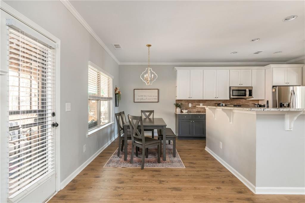 503 Pinnacle Court Canton, GA 30115 - Photo 16 of 51 a kitchen with stainless steel appliances granite countertop a stove top oven a sink a dining table and chairs