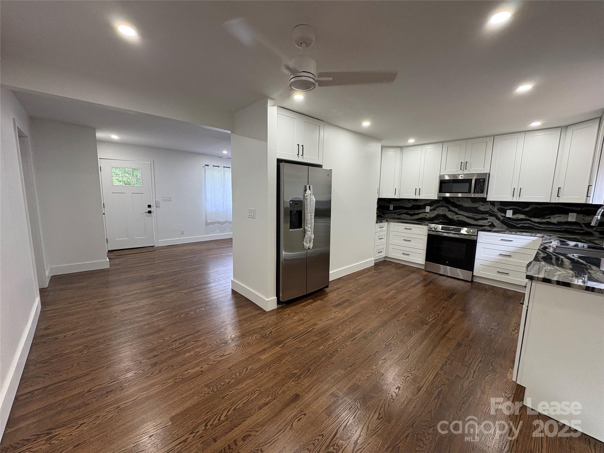 1175 Kilpatrick Road Hendersonville, NC 28739 - Photo 13 of 34 a kitchen with stainless steel appliances granite countertop a refrigerator a stove top oven a sink and dishwasher with wooden floor