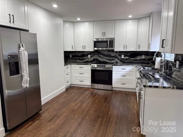 a kitchen with stainless steel appliances a stove a sink and a refrigerator