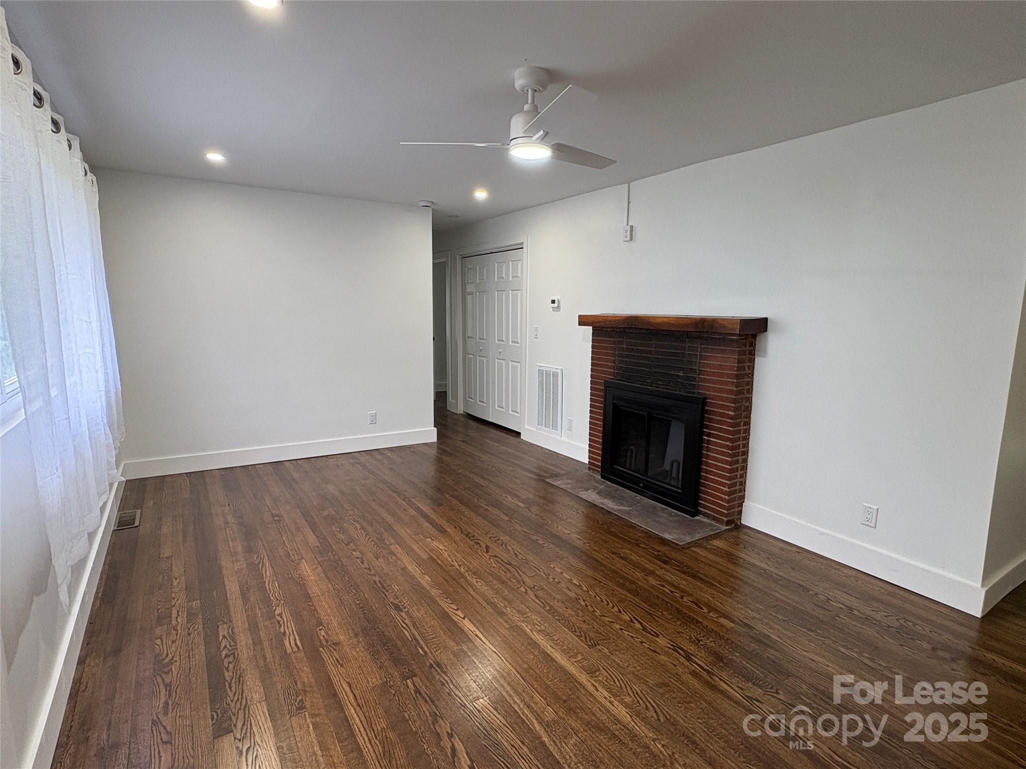 1175 Kilpatrick Road Hendersonville, NC 28739 - Photo 3 of 34 wooden floor in an empty room with a fireplace